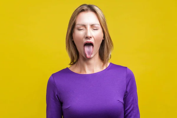 Retrato de mujer positiva y despreocupada demostrando lengua. interior —  Fotos de Stock