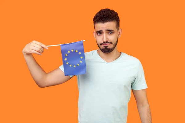 Bandera de la Unión Europea. Retrato de hombre morena trastornado sosteniendo EU f — Foto de Stock