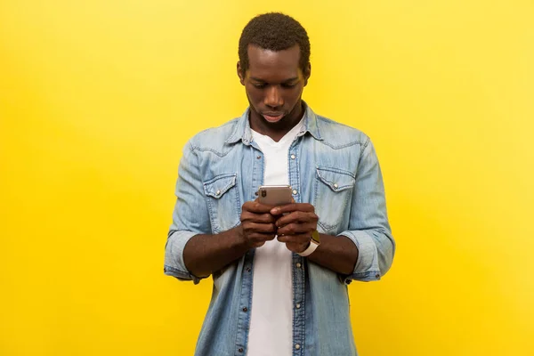 Portrait of serious man using cellphone, typing text message or — Stock Photo, Image