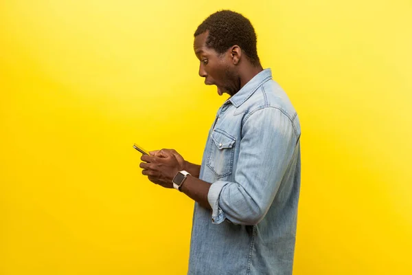 Seitenansicht des erstaunten Mannes mit Handy, SMS tippen — Stockfoto