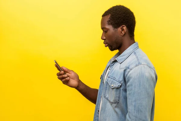 Seitenansicht von ernsthaften Mann mit Handy, SMS-Eingabe oder — Stockfoto