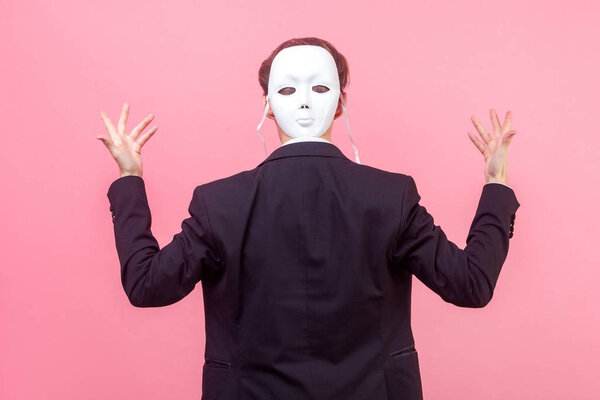Businessman in suit standing with raised hands and back turned t