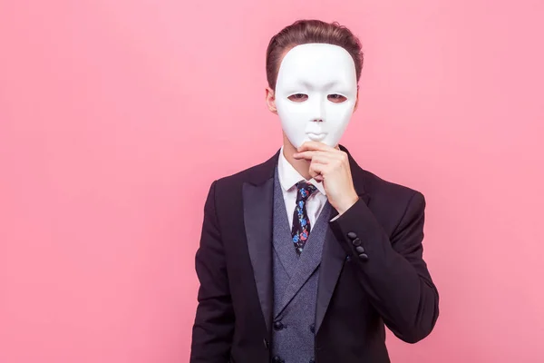 Молодой бизнесмен в черном костюме, закрывающий лицо — стоковое фото