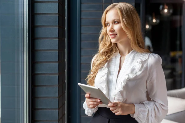 Retrato de la joven mujer de negocios bonita mirando por la ventana y sm — Foto de Stock