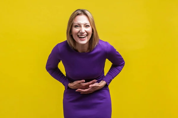 Portrait of joyous positive woman holding her hands on belly and — Stockfoto