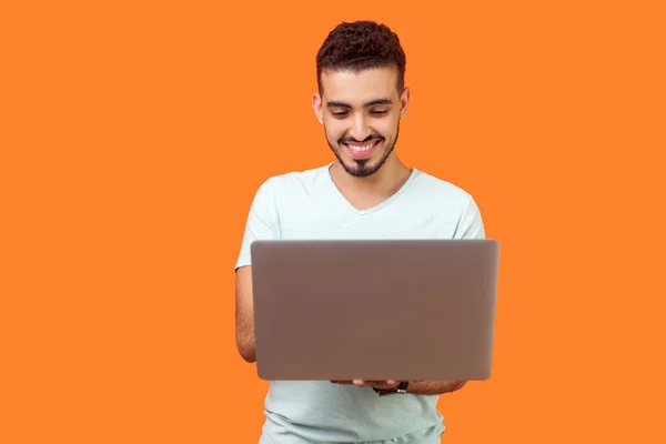 Portrait de joyeux jeune homme brune tapant sur ordinateur portable, surfin — Photo