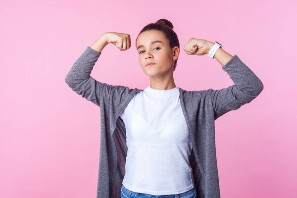 Portrait of self-confident teenage girl raising hands showing po