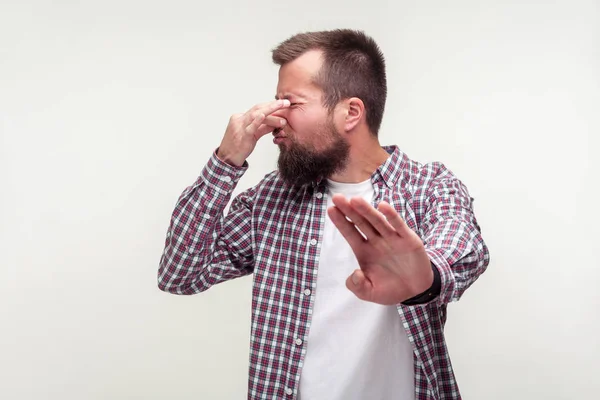 Portrait of confused bearded man showing stop gesture and pinchi — Stock Photo, Image
