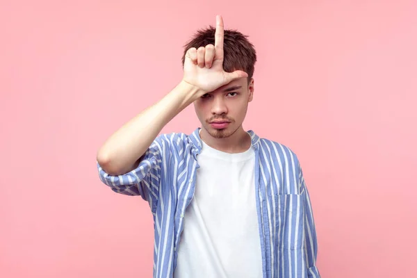 Portrait of depressed brown-haired man doing loser gesture with — Stock Photo, Image