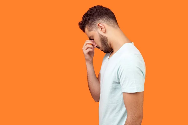 Zijaanzicht van depressieve brunette man verbergen gezicht in de hand, op zoek — Stockfoto