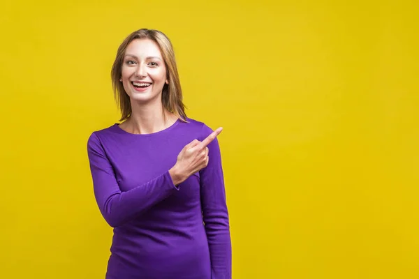 Olha aqui! Retrato de mulher atraente alegre de pé pointi — Fotografia de Stock