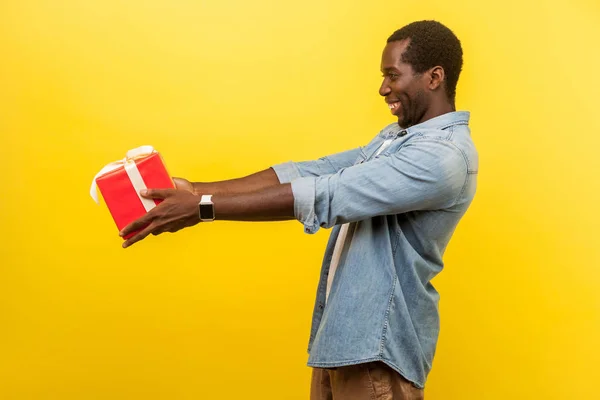 Nimm dieses Geschenk! Seitenansicht von großzügigen Mann in Jeans lässig shi — Stockfoto