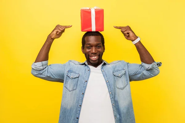 Retrato de homem satisfeito feliz apontando para caixa de presente vermelho em seu h — Fotografia de Stock