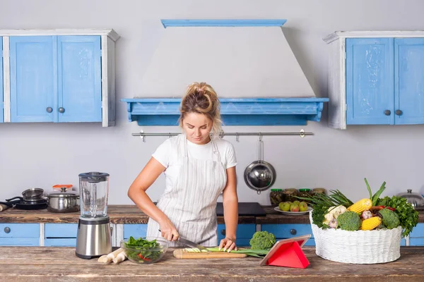 Pen dame i forkle som koker grønnsaker – stockfoto