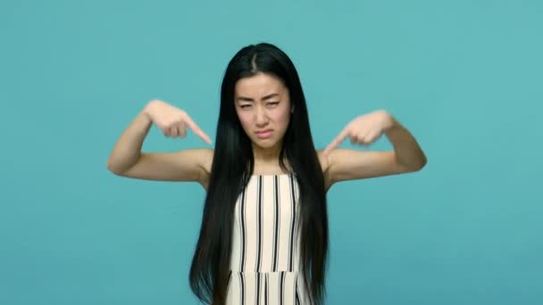 Sträng Asiatisk Kvinna Med Långt Rakt Svart Hår Pekar Nedåt — Stockvideo