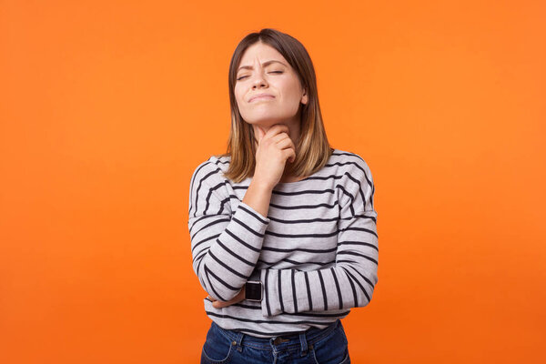 Portrait of ill woman with brown hair in long sleeve striped shi