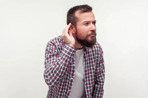 Retrato del hombre barbudo sordo de pie con la mano cerca de la oreja y la lis — Foto de Stock