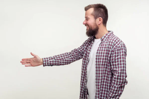 Zijaanzicht van vriendelijke man met baard reikend van hand tot hand schudden — Stockfoto
