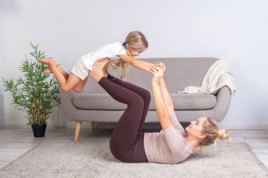 Küçük kızı Rais ile yoga yapan pozitif bir genç anne.