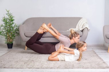 Sportif, genç bir anne ve çekici bir kız. Yoga yapıyor.