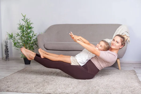 Mladá krásná matka a roztomilá dcera cvičit jógu spolu — Stock fotografie