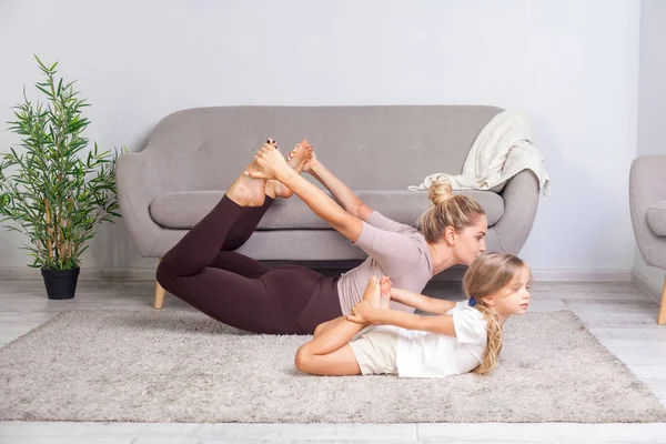 Sportovní mladá matka a okouzlující dcera praktikující jógu v h — Stock fotografie