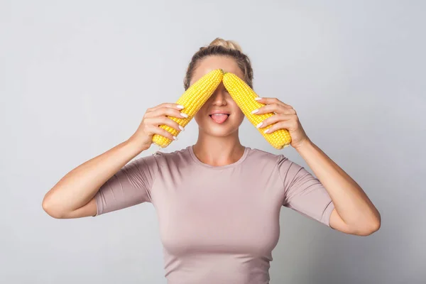 Portrait of funny woman covering eyes with corn cobs and stickin — 스톡 사진