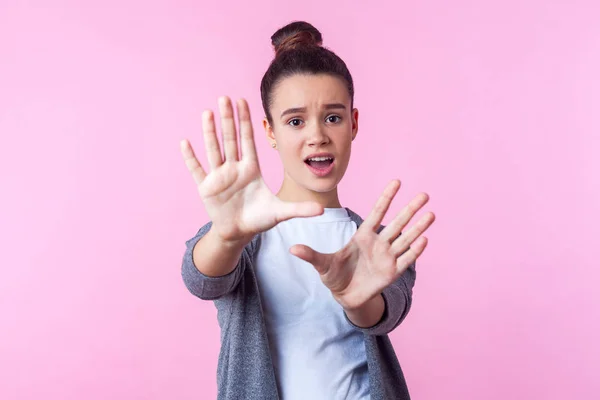 Portrait of scared brunette teenage girl raising palms with frig — ストック写真