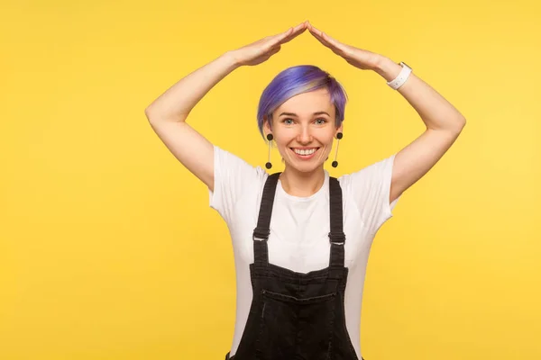 Sicherheit. Porträt eines fröhlichen Hipster-Mädchens, das Dachsymbole mit Witz schafft — Stockfoto