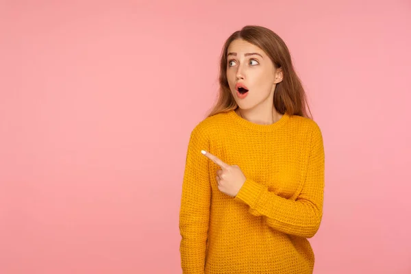 Wow, look! Portrait of amazed ginger girl in sweater pointing to — Stock Photo, Image