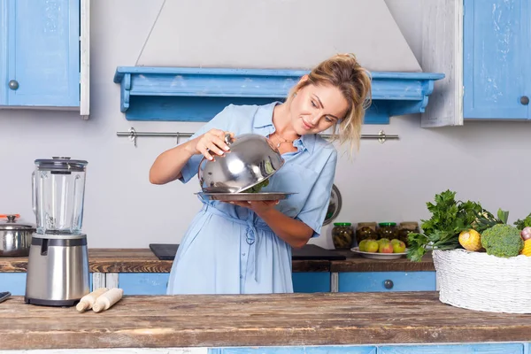 Positive charming woman looking under cloche checking dish on tr — 스톡 사진