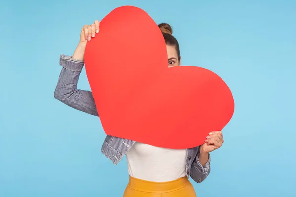 Retrato de la divertida mujer optimista asomándose del papel rojo grande — Foto de Stock