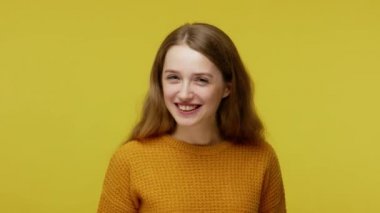 Humorous funny beautiful girl in pullover laughing, making fish face with pout lips and showing comical goofy grimace, carefree childish behavior. indoor studio shot isolated on yellow background