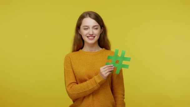 Усміхнена Дівчина Доброзичливим Виразом Обличчя Тримає Зелений Хеш Знак Піднімає — стокове відео