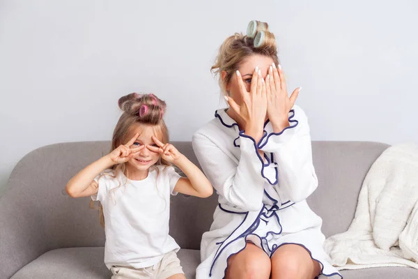 Nosy žena a její roztomilá dcera s natáčkami ve vlasech krytí e — Stock fotografie