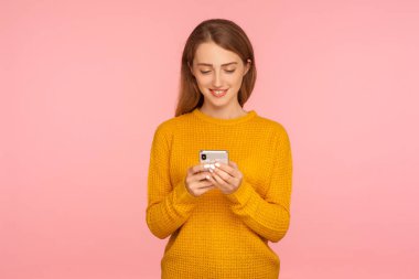 Pozitif kızıl kızın portresi cep telefonuna mesaj yazıyor.