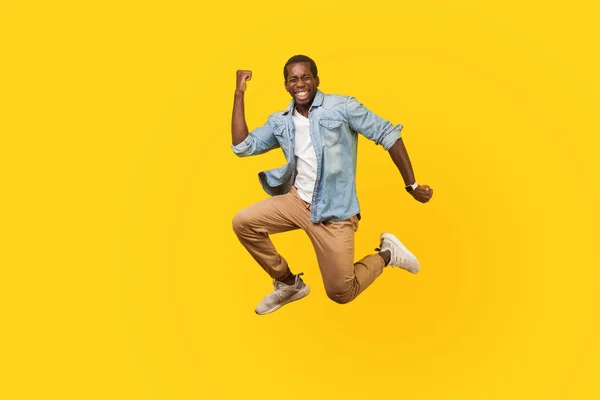 Full length portrait of joyous ecstatic man jumping for joy or f