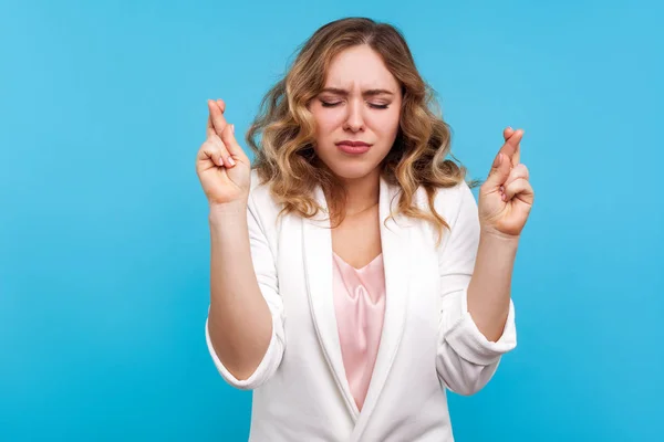 Portrait of hopeful woman standing with eyes closed and fingers — Stock Photo, Image