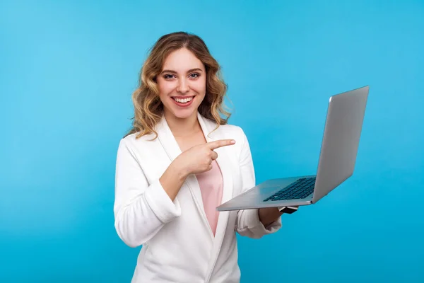Ritratto di bella donna d'affari che punta al computer portatile e sorride — Foto Stock