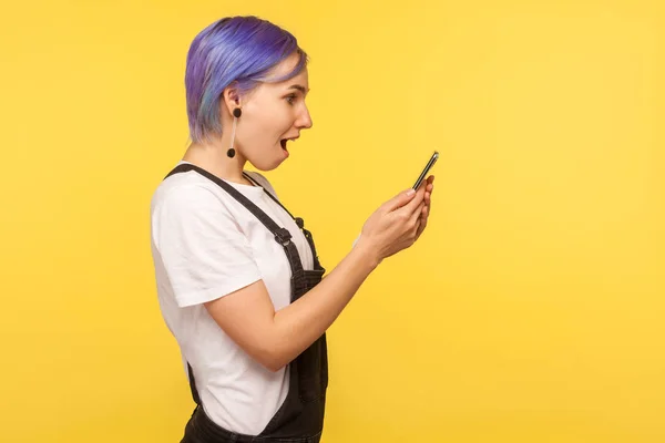 Side view of amazed hipster girl using cell phone, texting or re — Stock Photo, Image