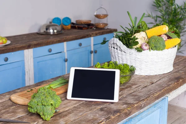 Tablettdator, färska grönsaker och kokt sallad på träbord i — Stockfoto