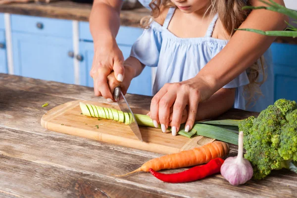 Primer plano de la madre y el niño picando verduras con cuchillo en boa — Foto de Stock