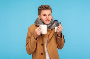 Ev tedavisi. Güz paltosu ve atkısı olan grip hastası bir adam mı tutuyor?