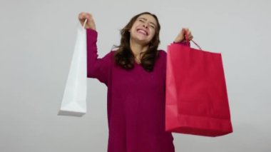 Happy enthusiastic shopper, joyful brunette woman in pullover holding shopping bags