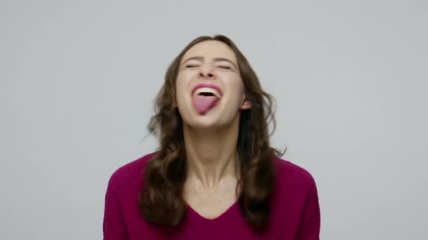 Funny playful nice-looking brunette woman in pullover sticking out tongue, having fun — 图库视频影像