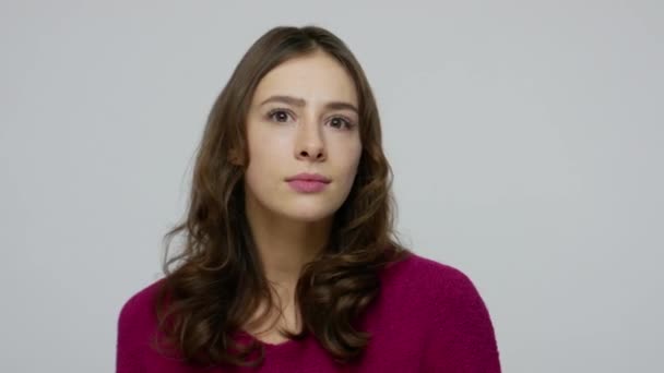 Close-up van aantrekkelijke vriendelijke brunette vrouw draaien, kijken in de camera met interesse en glimlachen — Stockvideo