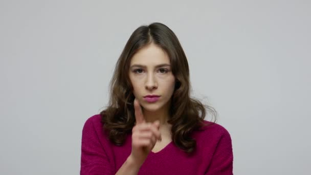 Shh, don't speak! Closeup of nice-looking brunette woman putting finger on lips, making silence gesture — Stok video