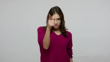 Hey, don't make me mad! Annoyed brunette woman in pullover pointing to camera with angry expression
