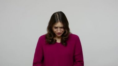 Dramatic upset brunette woman in pullover crying and hiding her face in hands, feeling desperate