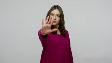 Prohibition, denial concept! Nice-looking brunette woman in pullover gesturing stop sign with palm